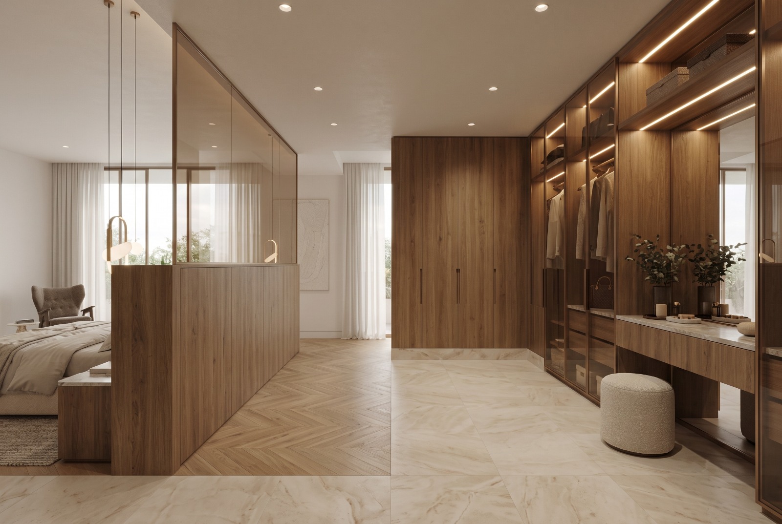 The walk-in wardrobe: lit glass-front wardrobes and a marble-topped vanity in walnut, a bouclé stool on a marble floor, and the bedroom beyond the bronze glass screen